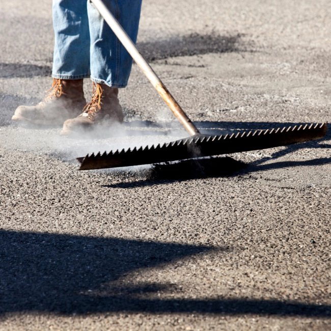 worker filling a crack on the street